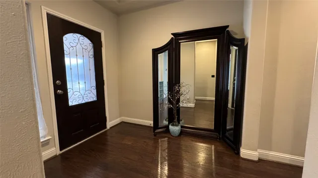 an empty room with wooden floor and a mirror