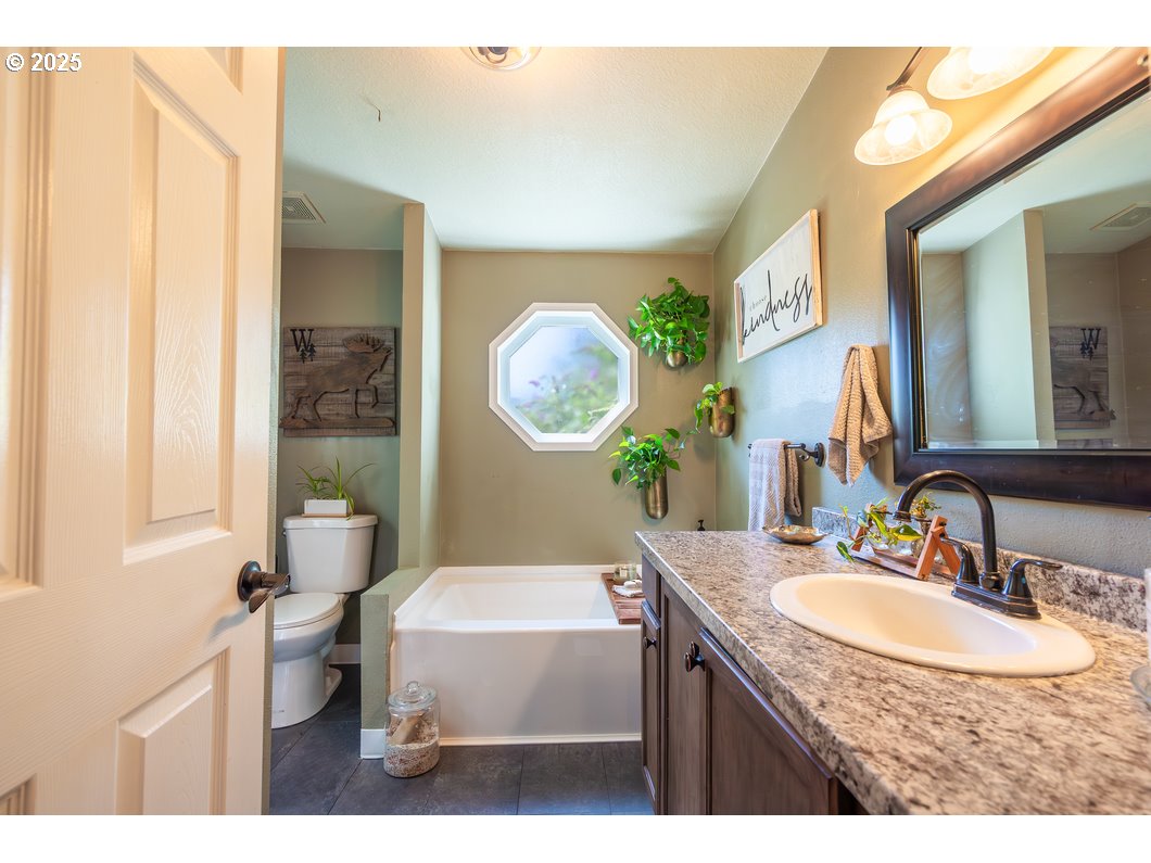 165 8th Place Mill City, OR 97360 - Photo 11 of 39 a bathroom with a granite countertop sink mirror and a toilet