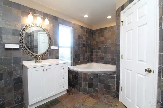 a bathroom with a sink mirror and shower