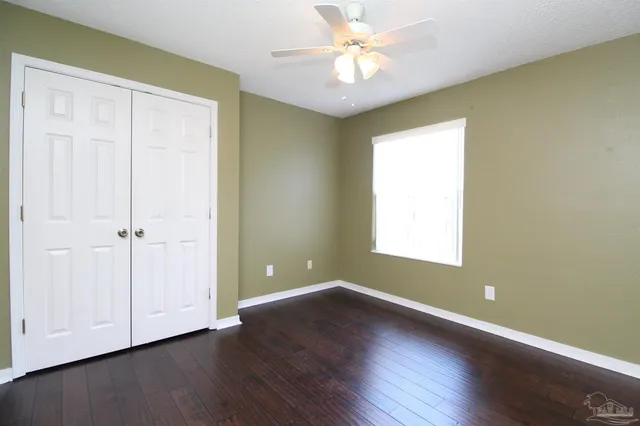 an empty room with wooden floor and window
