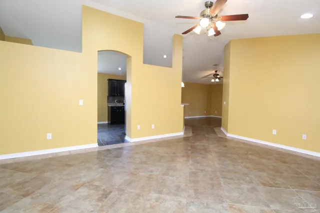 a view of a big room with wooden floor and a ceiling fan