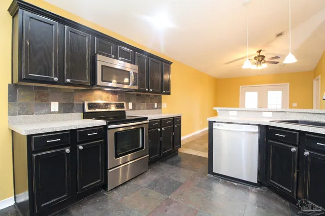 a kitchen with stainless steel appliances granite countertop a sink stove and microwave
