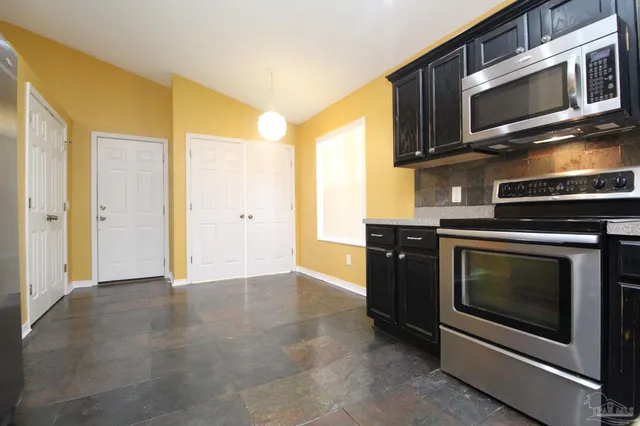 a view of an empty room with a fireplace and a window