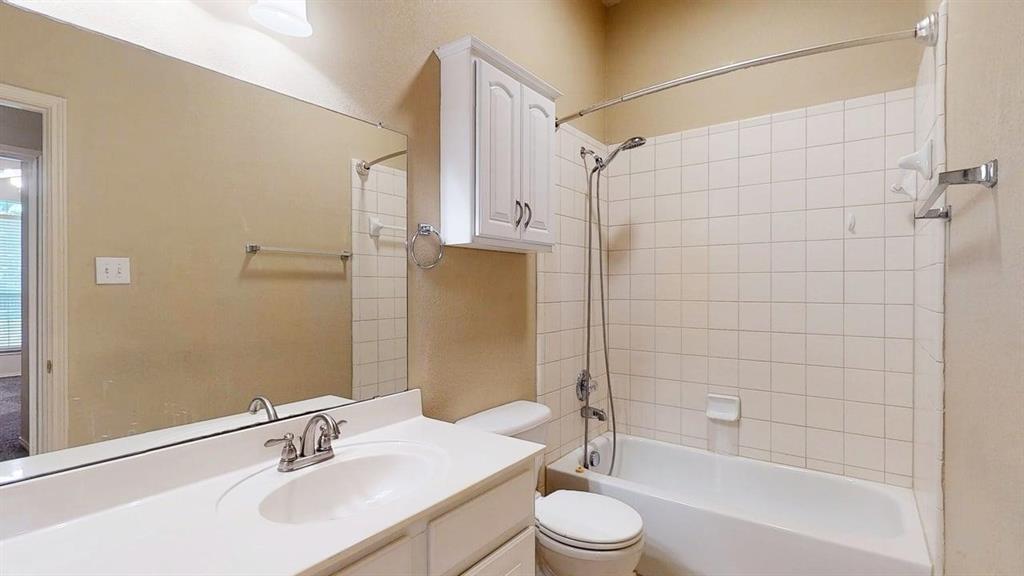 1910 Wickersham Lane Corinth, TX 76210 - Photo 28 of 38 a bathroom with a bathtub shower sink vanity mirror and toilet