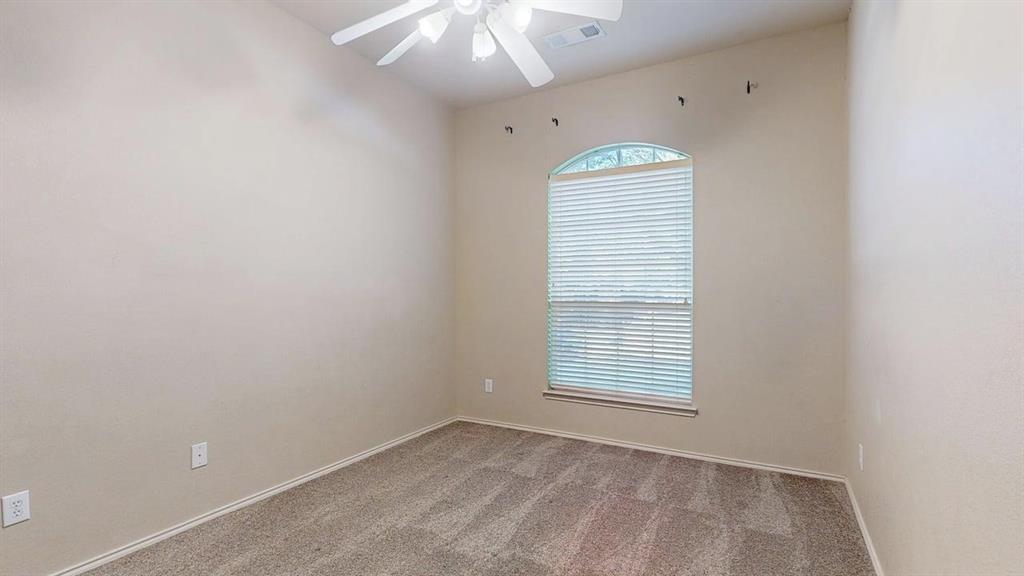 1910 Wickersham Lane Corinth, TX 76210 - Photo 29 of 38 an empty room with a ceiling fan and window