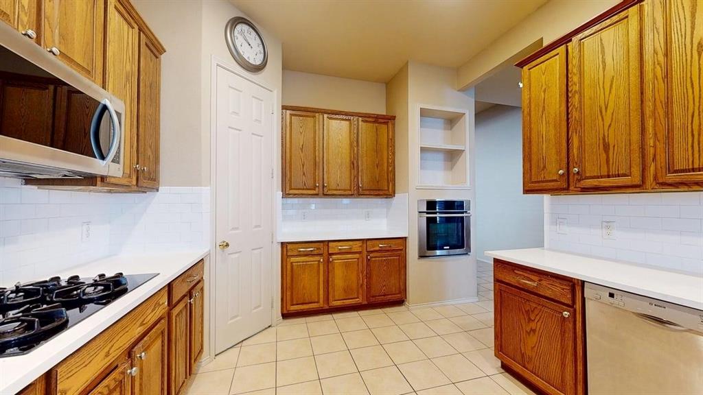 1910 Wickersham Lane Corinth, TX 76210 - Photo 3 of 38 a kitchen with stainless steel appliances granite countertop a stove and a sink