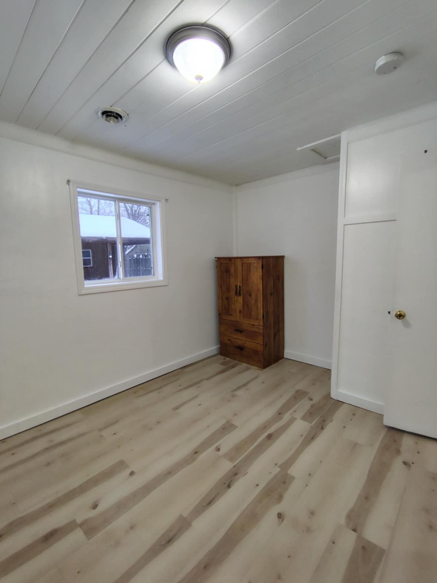 23809 Shelby Road Lowell, IN 46356 - Photo 11 of 19 an empty room with wooden floor and windows