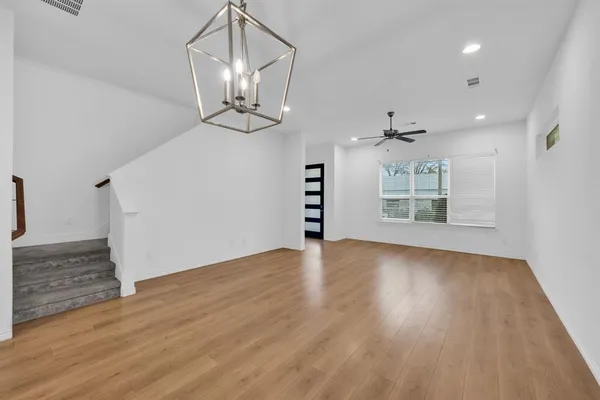 a view of a livingroom with a ceiling fan wooden floor and window