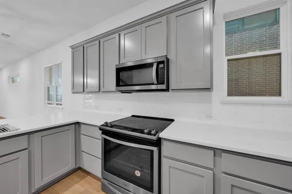 a kitchen with stainless steel appliances a stove microwave and sink