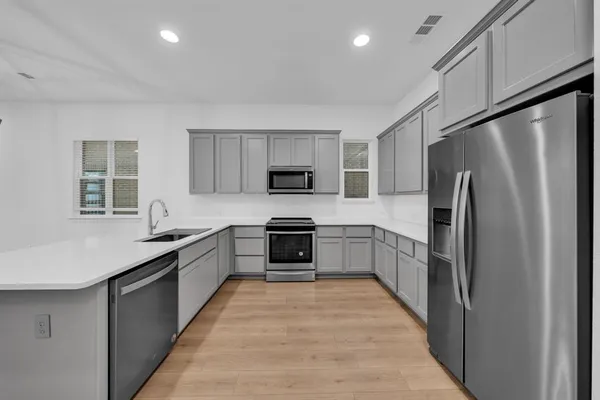 a large kitchen with cabinets stainless steel appliances and a counter space