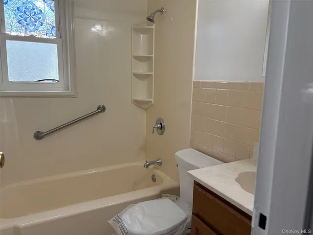 a bathroom with a granite countertop sink a toilet and shower