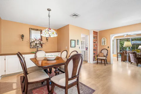 a dining room with furniture a chandelier and wooden floor
