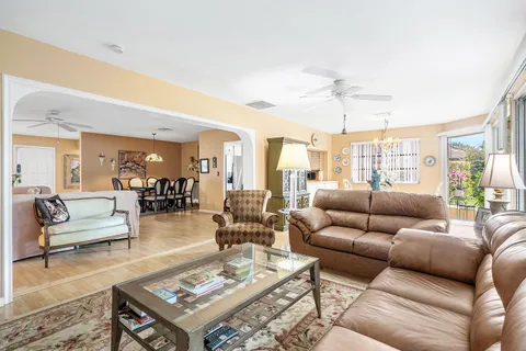 a dining room with furniture a chandelier and wooden floor