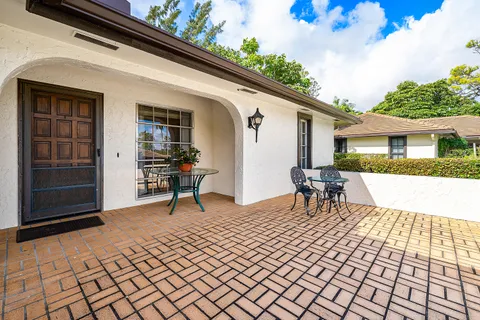a view of a patio with table and chairs with wooden floor and fence