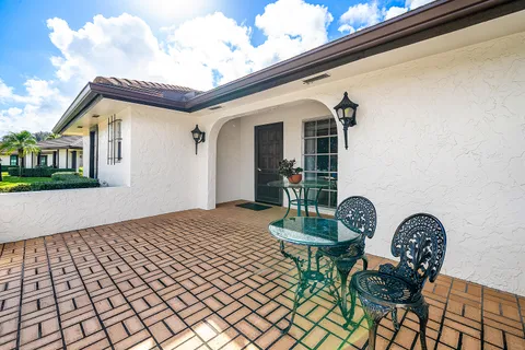a front view of a house with garden and patio