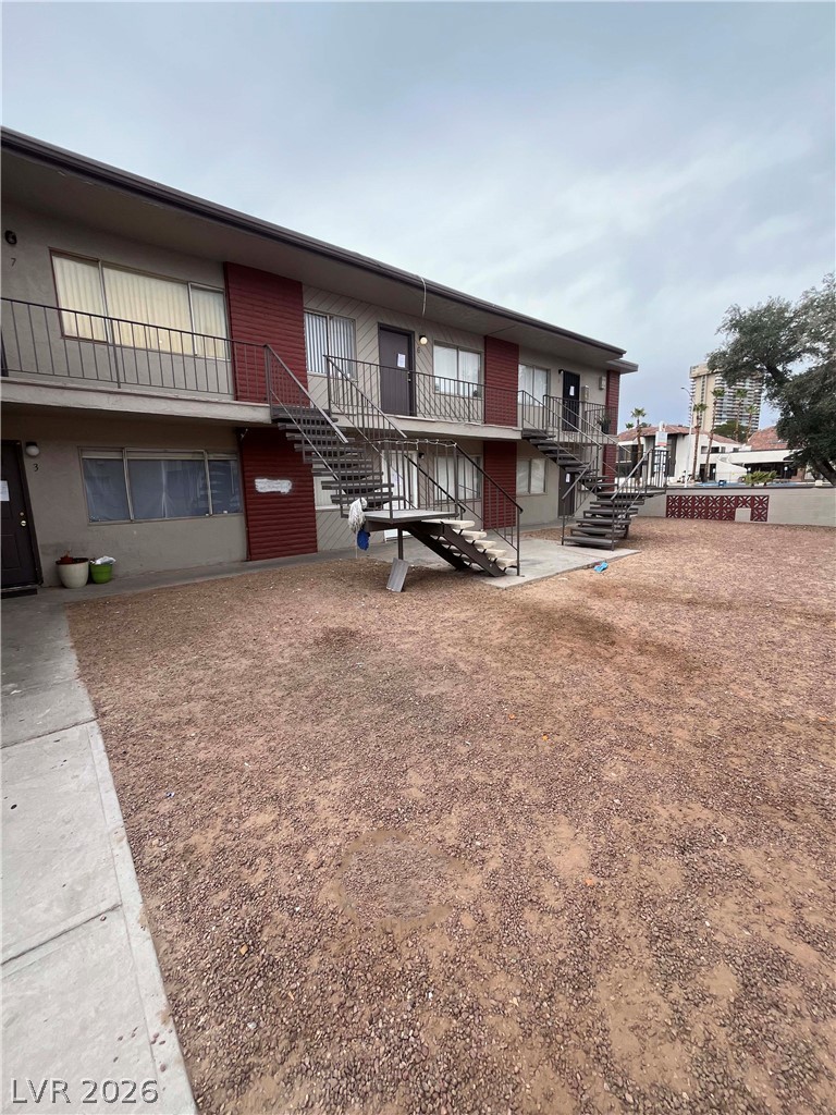 A classic two-story apartment building with external staircases offers convenient access to each unit.