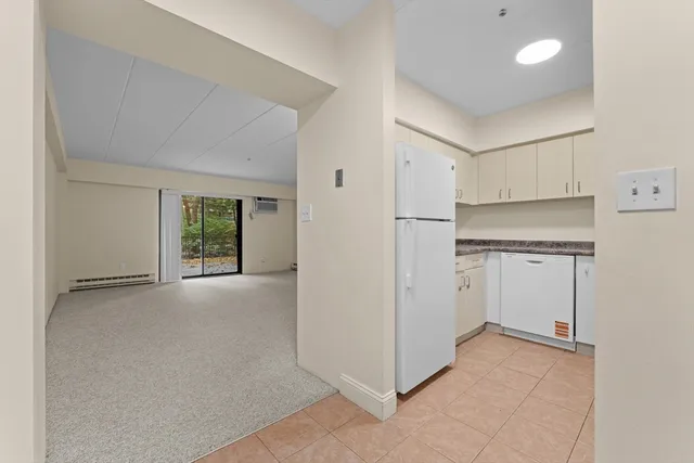 a view of a kitchen with white cabinets and a refrigerator