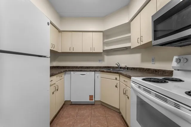 a kitchen with granite countertop cabinets stainless steel appliances and a sink