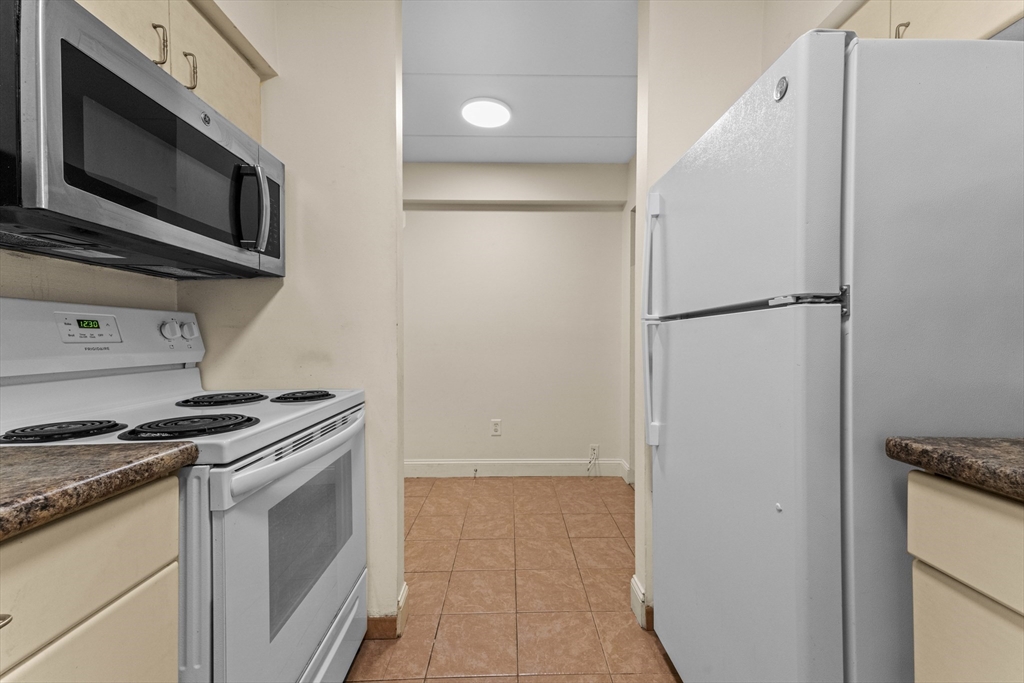 135 Pleasant Street, Unit 106 Brookline, MA 02446 - Photo 19 of 27 a kitchen with a stove microwave and refrigerator