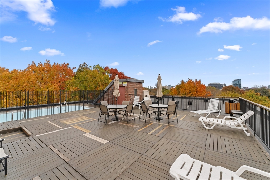 135 Pleasant Street, Unit 106 Brookline, MA 02446 - Photo 3 of 27 a view of a rooftop deck with chairs and wooden floor