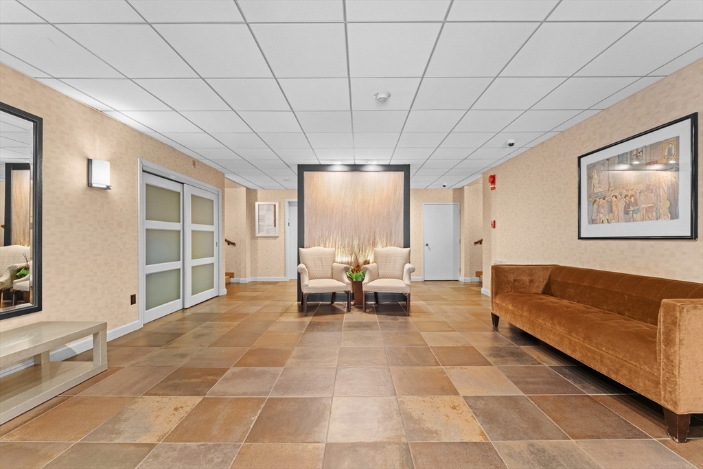 135 Pleasant Street, Unit 106 Brookline, MA 02446 - Photo 9 of 27 a living room with furniture and large windows