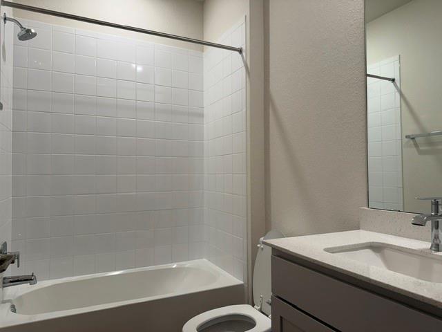 10609 Defender Trail Austin, TX 78754 - Photo 5 of 11 A well-appointed bathroom features a sparkling tub-shower combination and a vanity with a sleek countertop.
