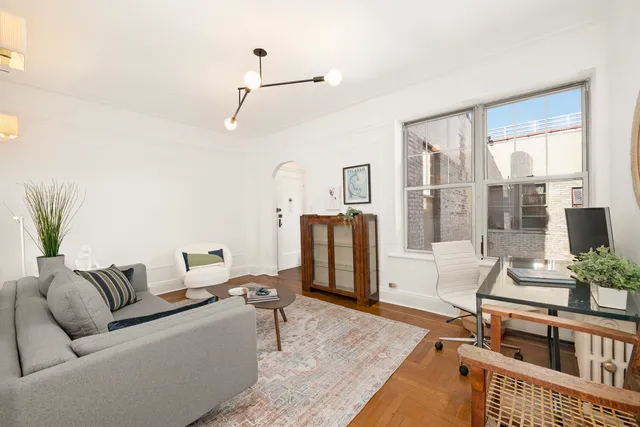 a living room with furniture a fireplace and a potted plant