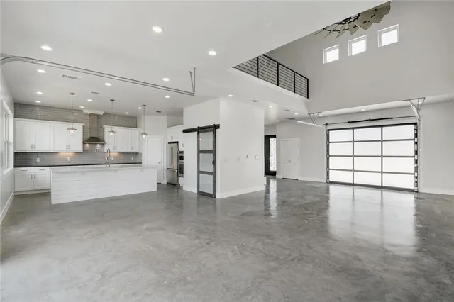 a view of an empty room with kitchen appliances and a window