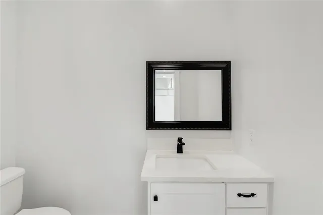 a bathroom with a sink a toilet and mirror