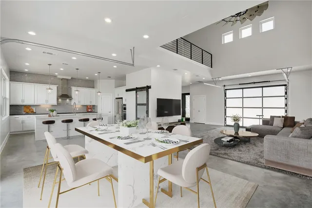 a room with stainless steel appliances kitchen island a table and chairs in it