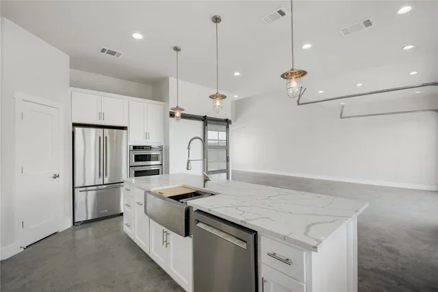 a kitchen with refrigerator a table and chairs