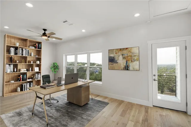 a living room with furniture a rug potted plant and a large window