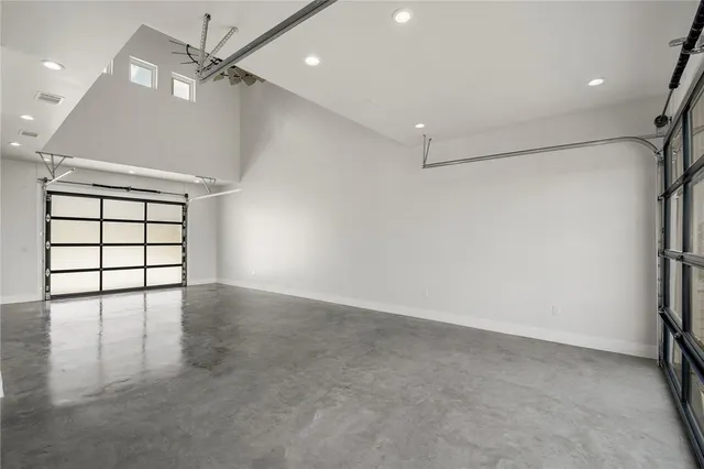 an empty room with windows and ceiling fan