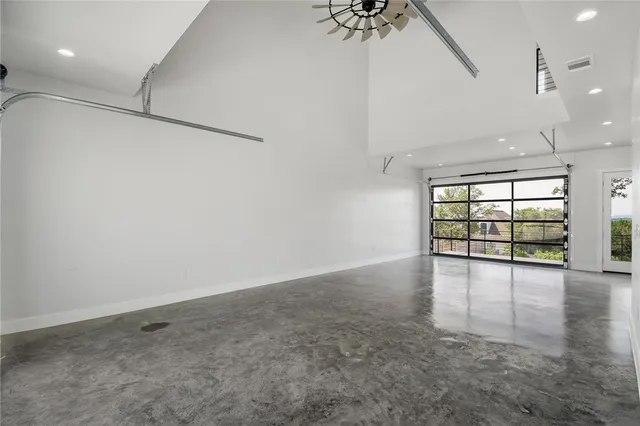 an empty room with windows and ceiling fan