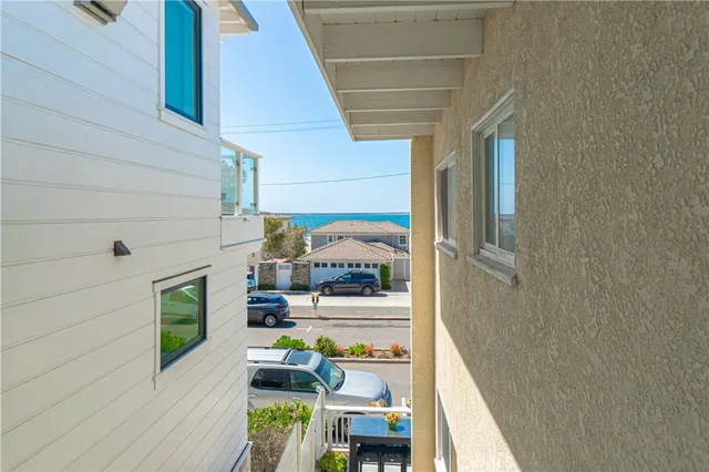 a kitchen with a sink dishwasher and white cabinets with wooden floor