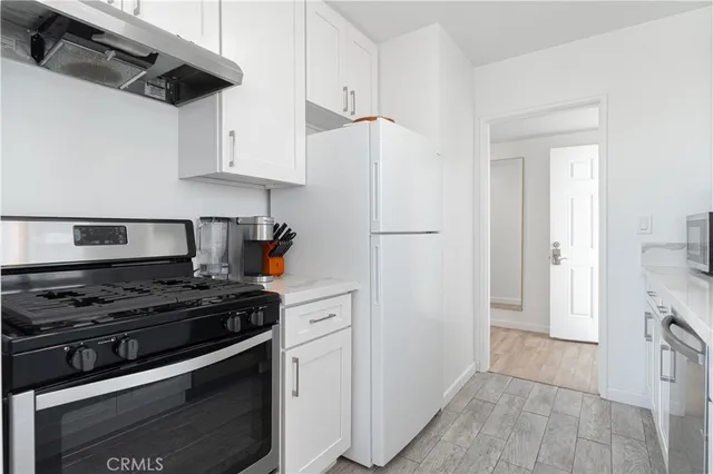 a kitchen with white cabinets and stainless steel appliances
