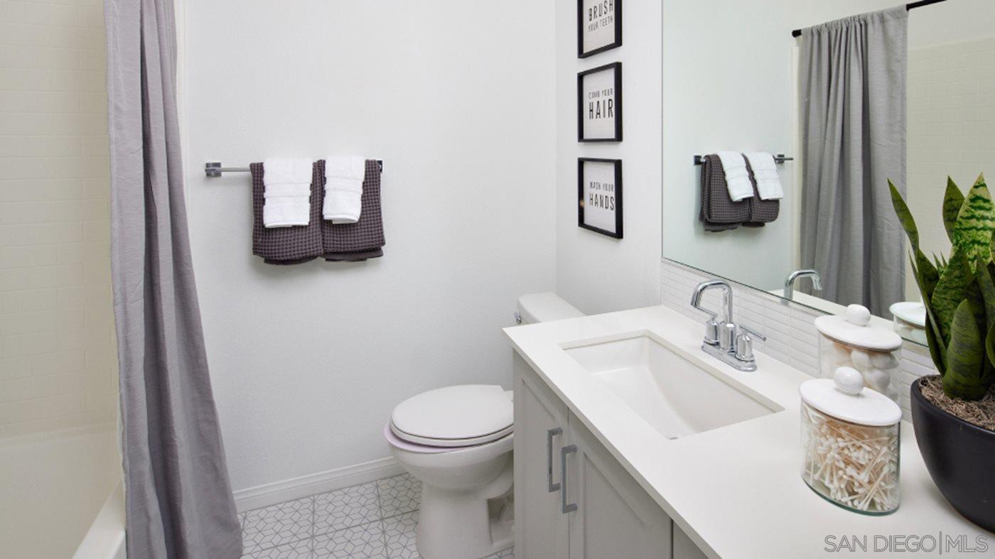 2021 Bluestone Circle, Unit HS71 PLAN Chula Vista, CA 91913 - Photo 11 of 12 a bathroom with a sink a toilet and mirror