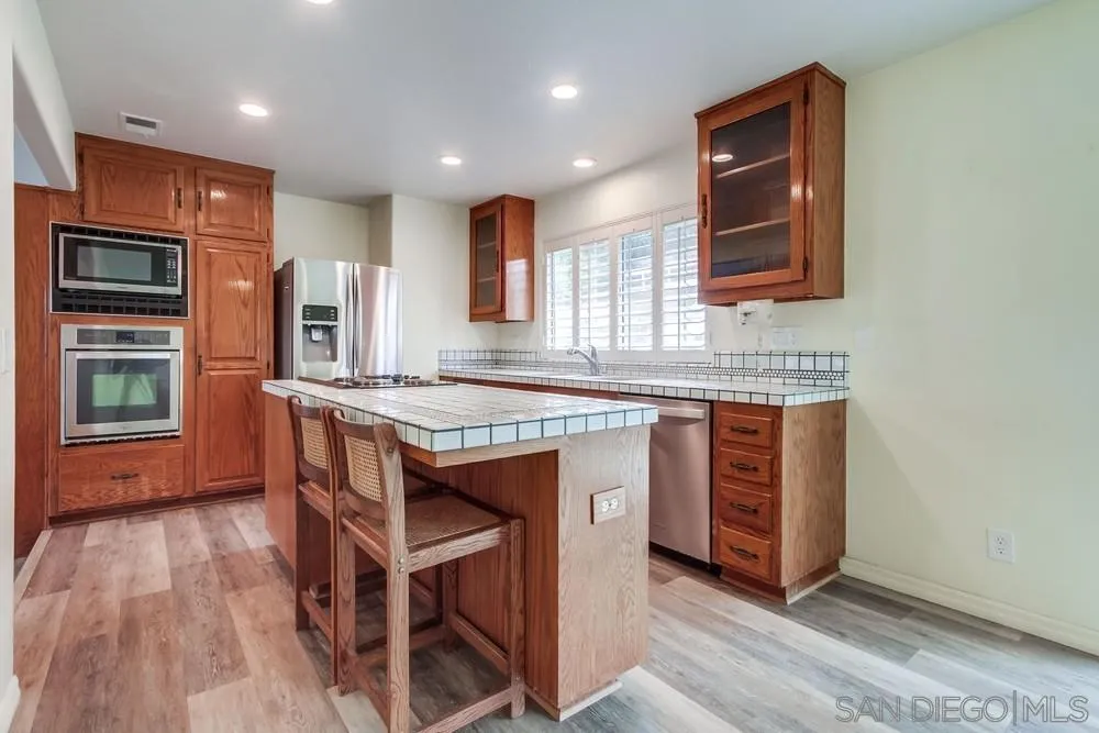 227 Hutchison Street Vista, CA 92084 - Photo 16 of 58 a kitchen with granite countertop a stove a sink and a refrigerator