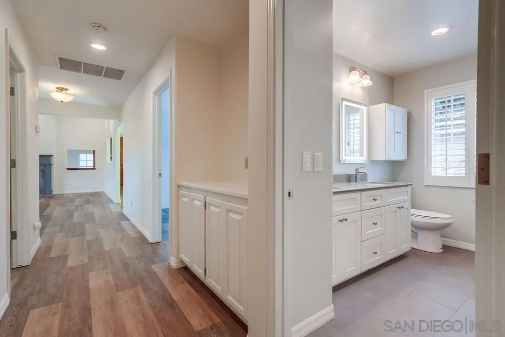 227 Hutchison Street Vista, CA 92084 - Photo 26 of 58 a bathroom with a granite countertop toilet a sink and a mirror