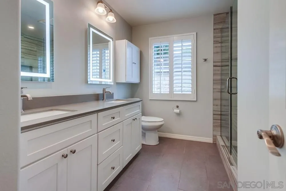 227 Hutchison Street Vista, CA 92084 - Photo 27 of 58 a bath room with a toilet a sink and a window