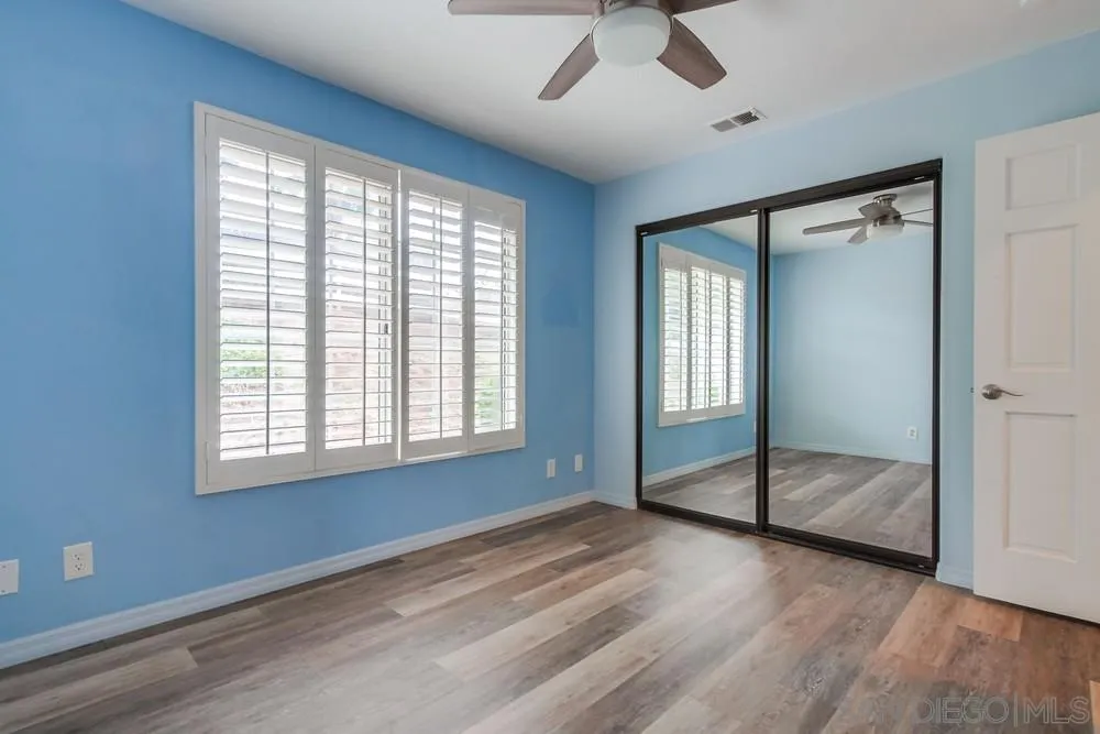 227 Hutchison Street Vista, CA 92084 - Photo 31 of 58 a view of an empty room with window and wooden floor