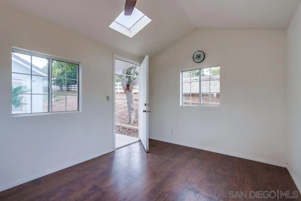 227 Hutchison Street Vista, CA 92084 - Photo 43 of 58 a view of an empty room with a window and wooden floor