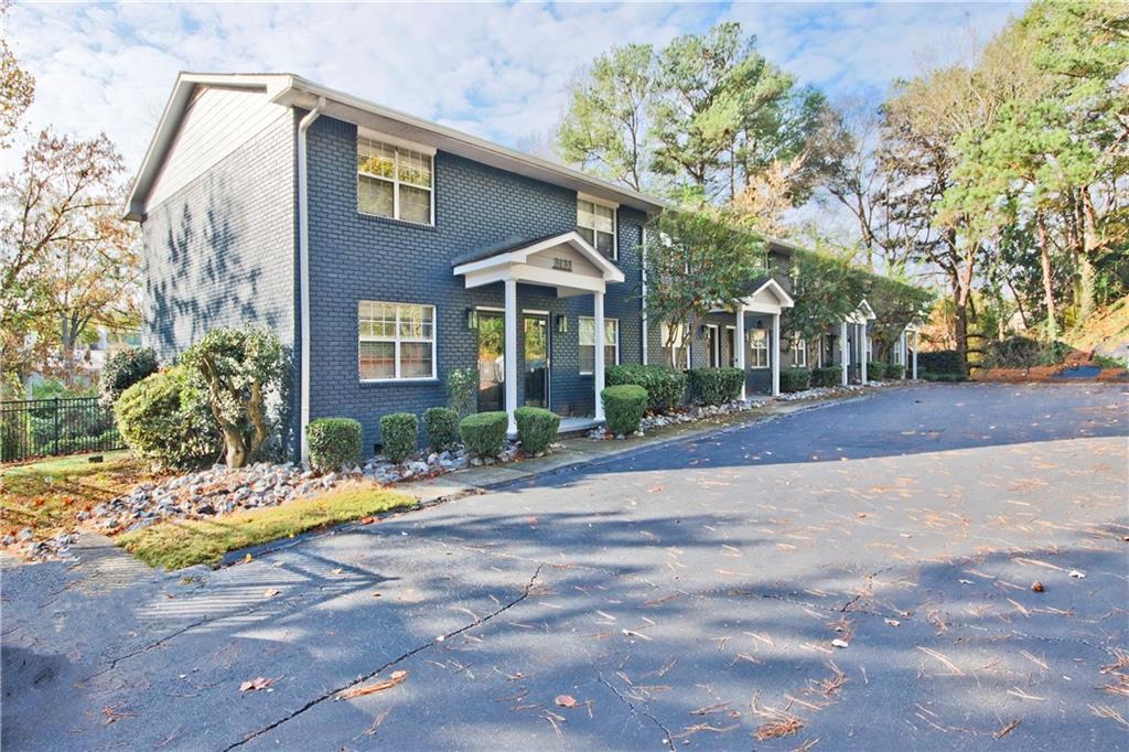 a front view of a house with yard and trees around
