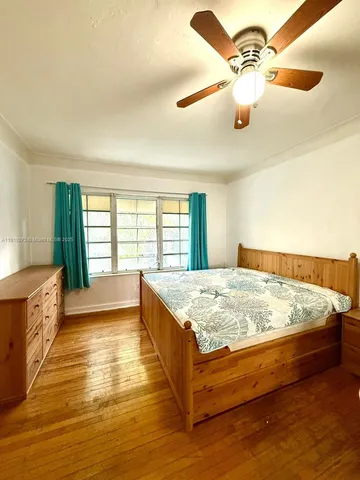a spacious bedroom with a bed and a large window