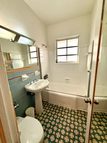 a bathroom with a sink a toilet a mirror and shower