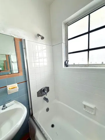 a bathroom with a tub sink and a window
