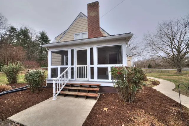 a backyard of a house with barbeque oven and wooden fence