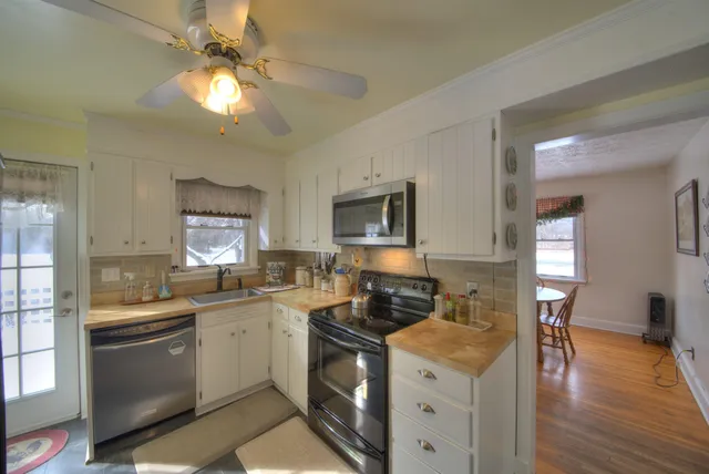 a view of kitchen with stainless steel appliances cabinets and a refrigerator