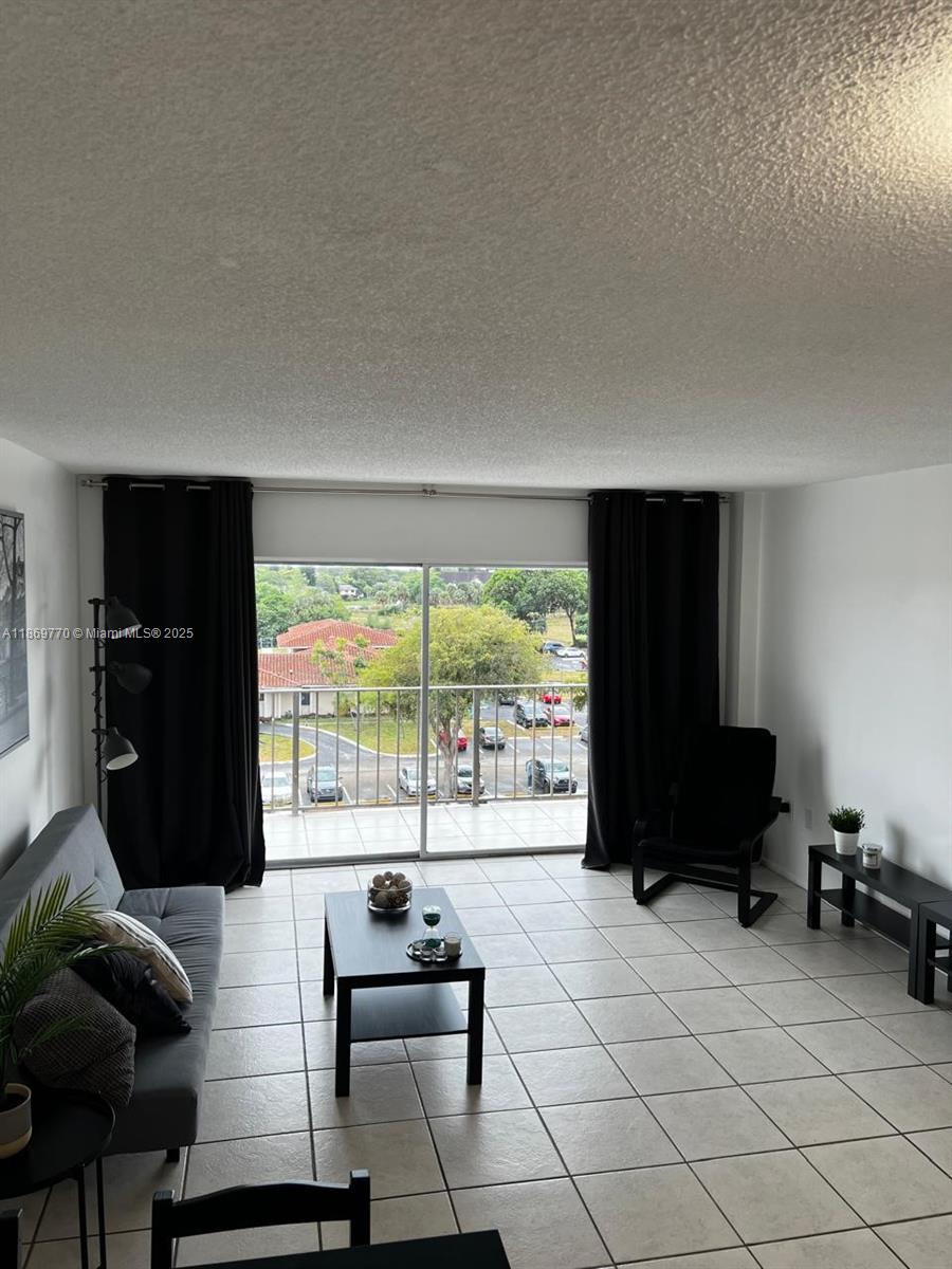 4164 Inverrary Drive, Unit 510 Lauderhill, FL 33319 - Photo 12 of 21 a living room with furniture and a floor to ceiling window