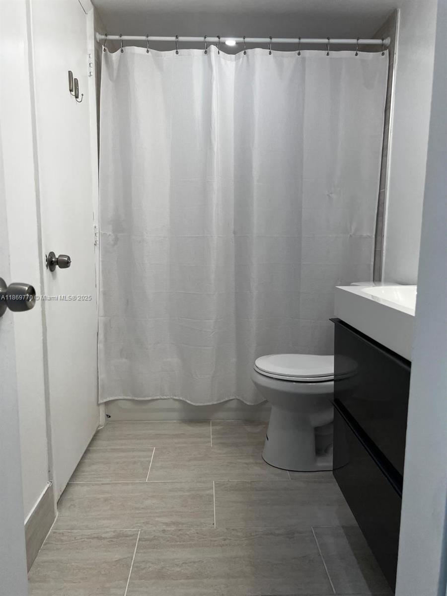 4164 Inverrary Drive, Unit 510 Lauderhill, FL 33319 - Photo 13 of 21 a bathroom with a toilet and a shower curtain